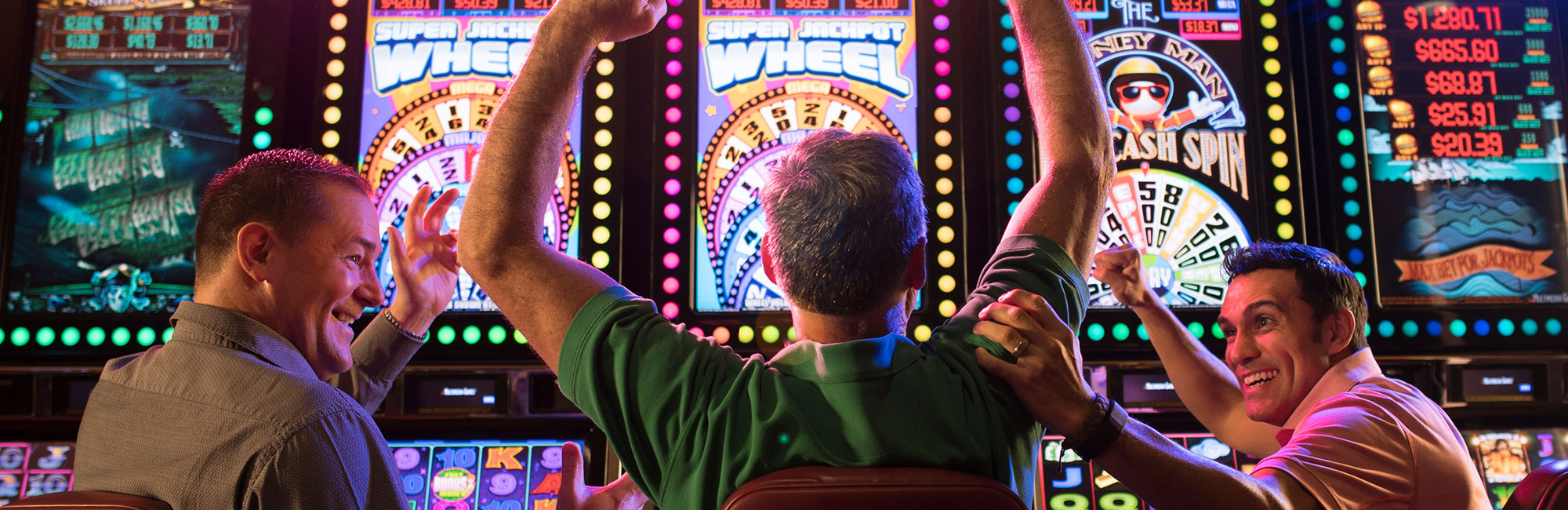 Three men winning at the slot machines